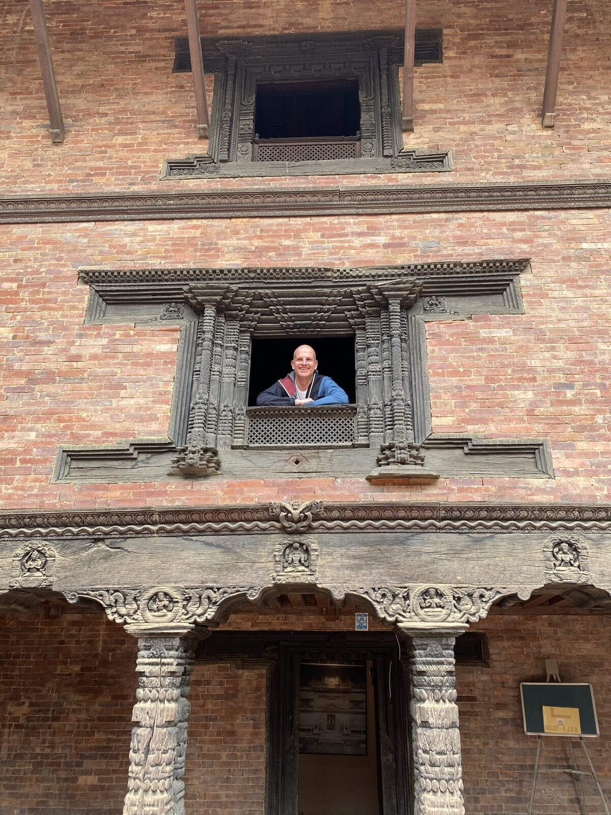 Thorsten Enderlin in einem geschnitzten Holzfenster eines alten Hauses in Patan