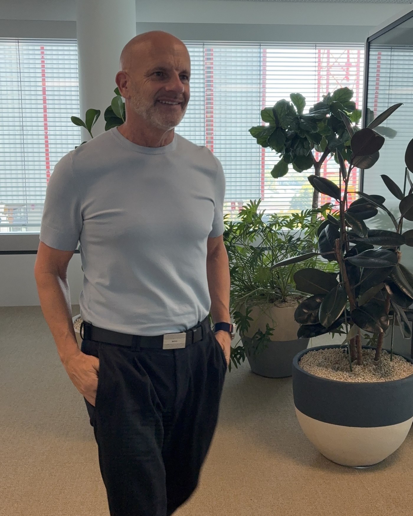 Thorsten Enderlin lächelnd im hellblauen Shirt, in einem lichtdurchfluteten Büro