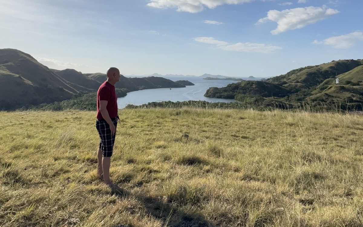 Thorsten Enderlin standing in a meadow, looking out over a bay