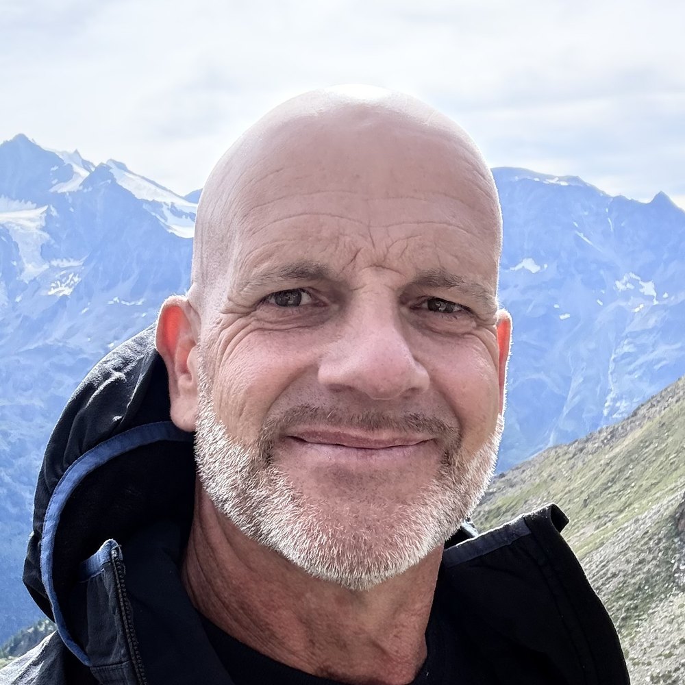 Thorsten Enderlin lächelt vor schneebedeckten Bergen