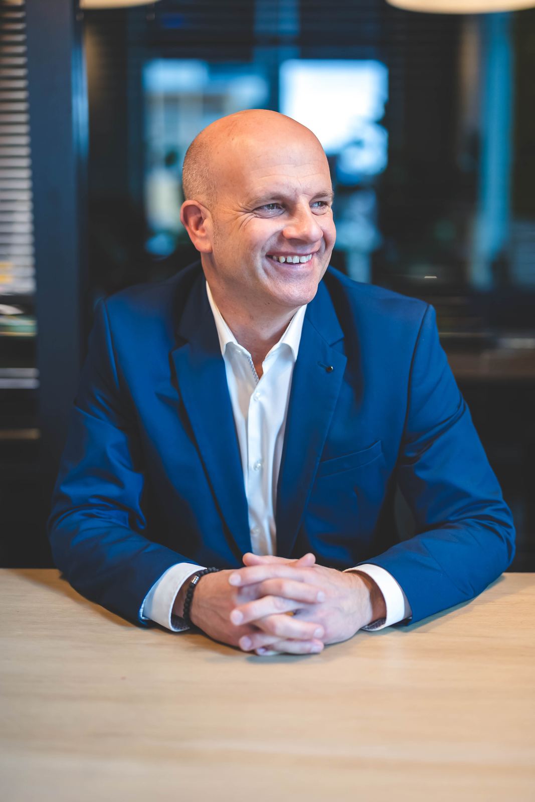 Thorsten Enderlin in a blue jacket, smiling at a table