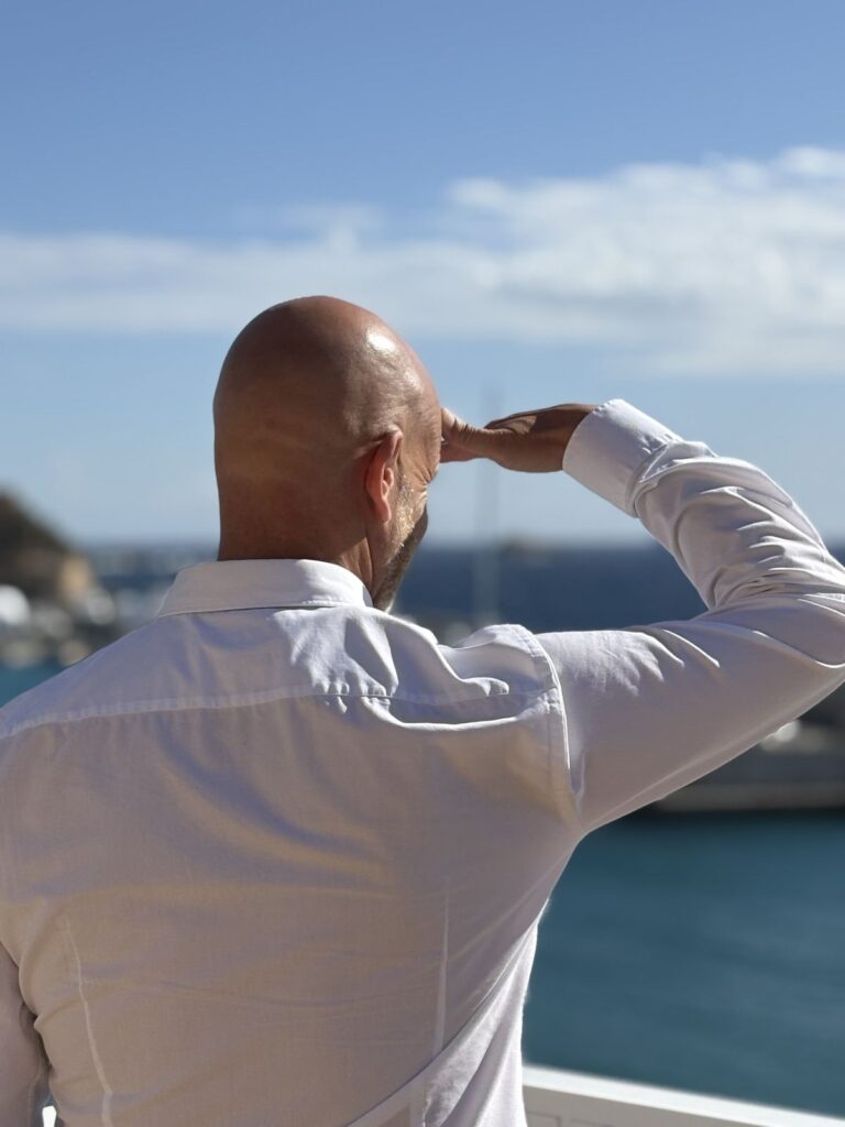 Thorsten Enderlin hält die Hand über die Augen und schaut aufs Meer