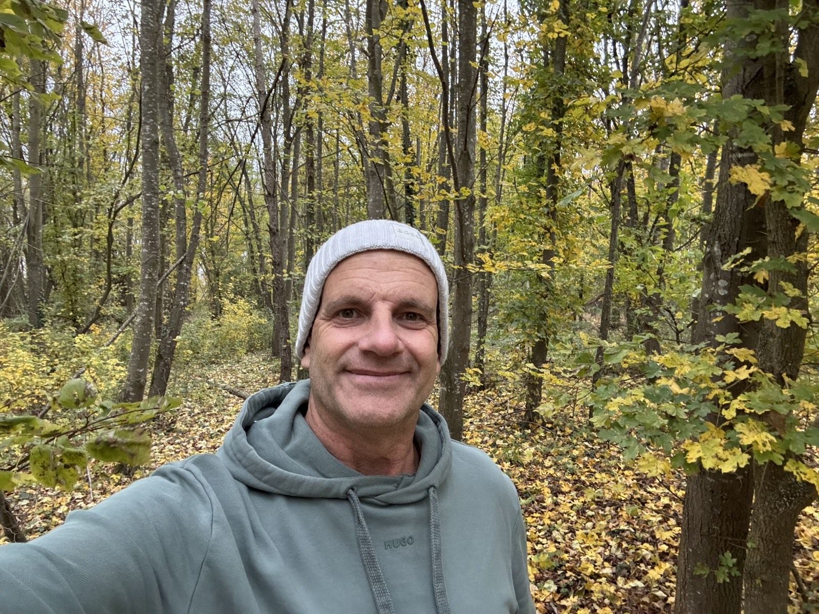 Thorsten Enderlin lächelt im herbstlichen Wald